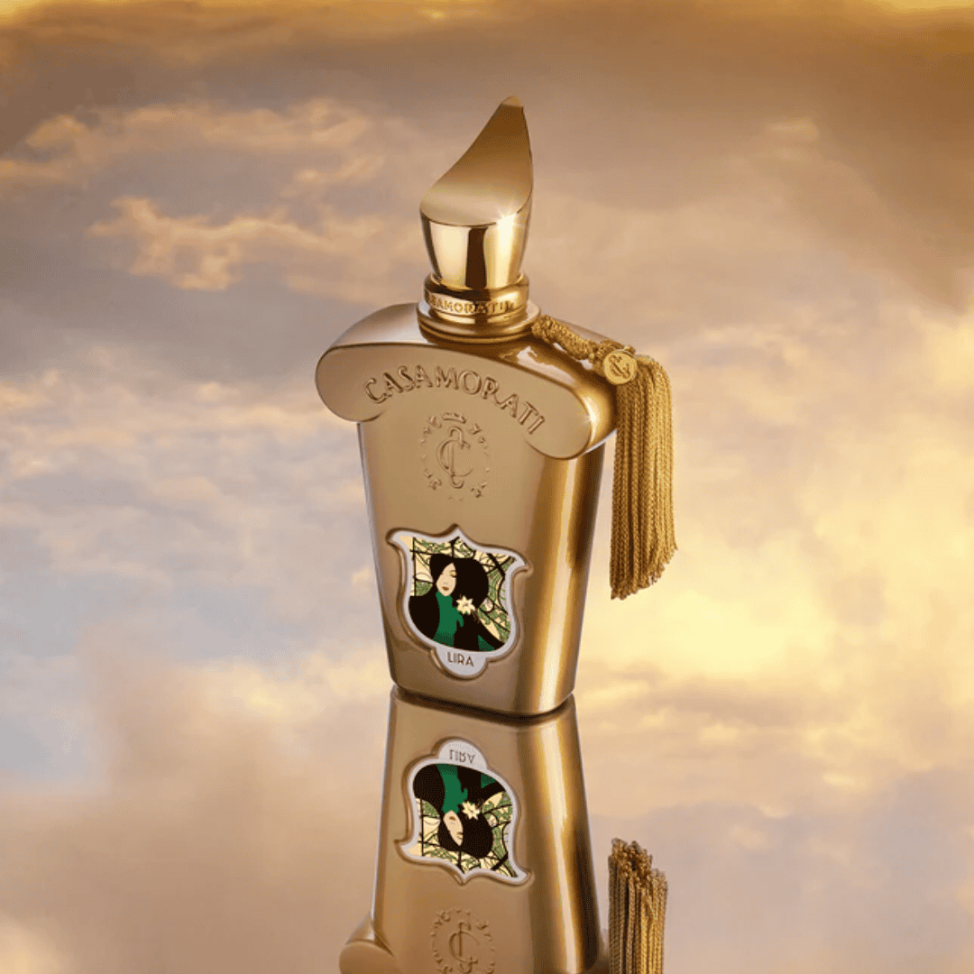 Csillogó Casamorati Lira parfüm üveg, arany színben, naplemente háttérrel.